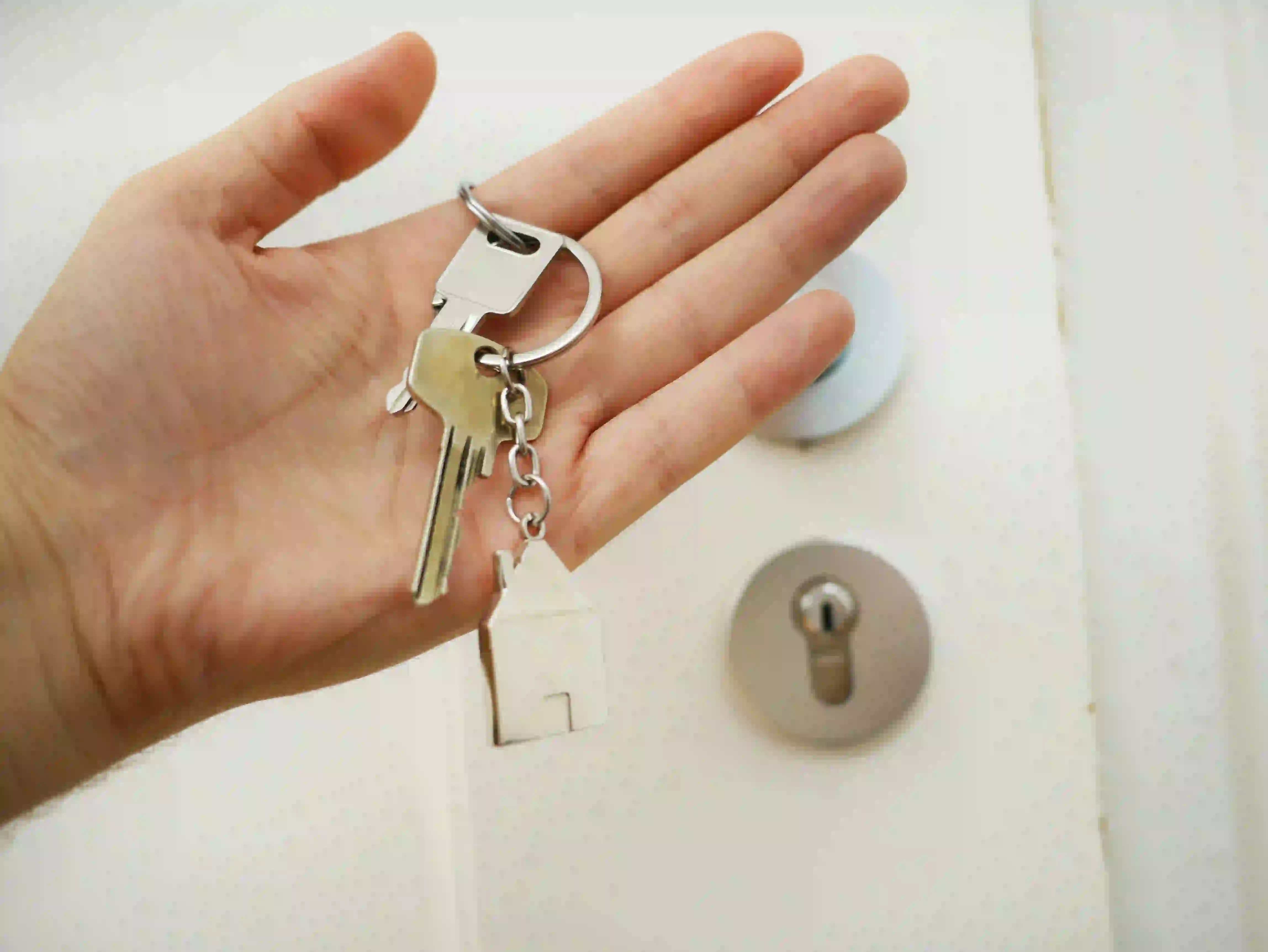 Hand holding house keys, showcasing real estate agent branded content ideas for website.
