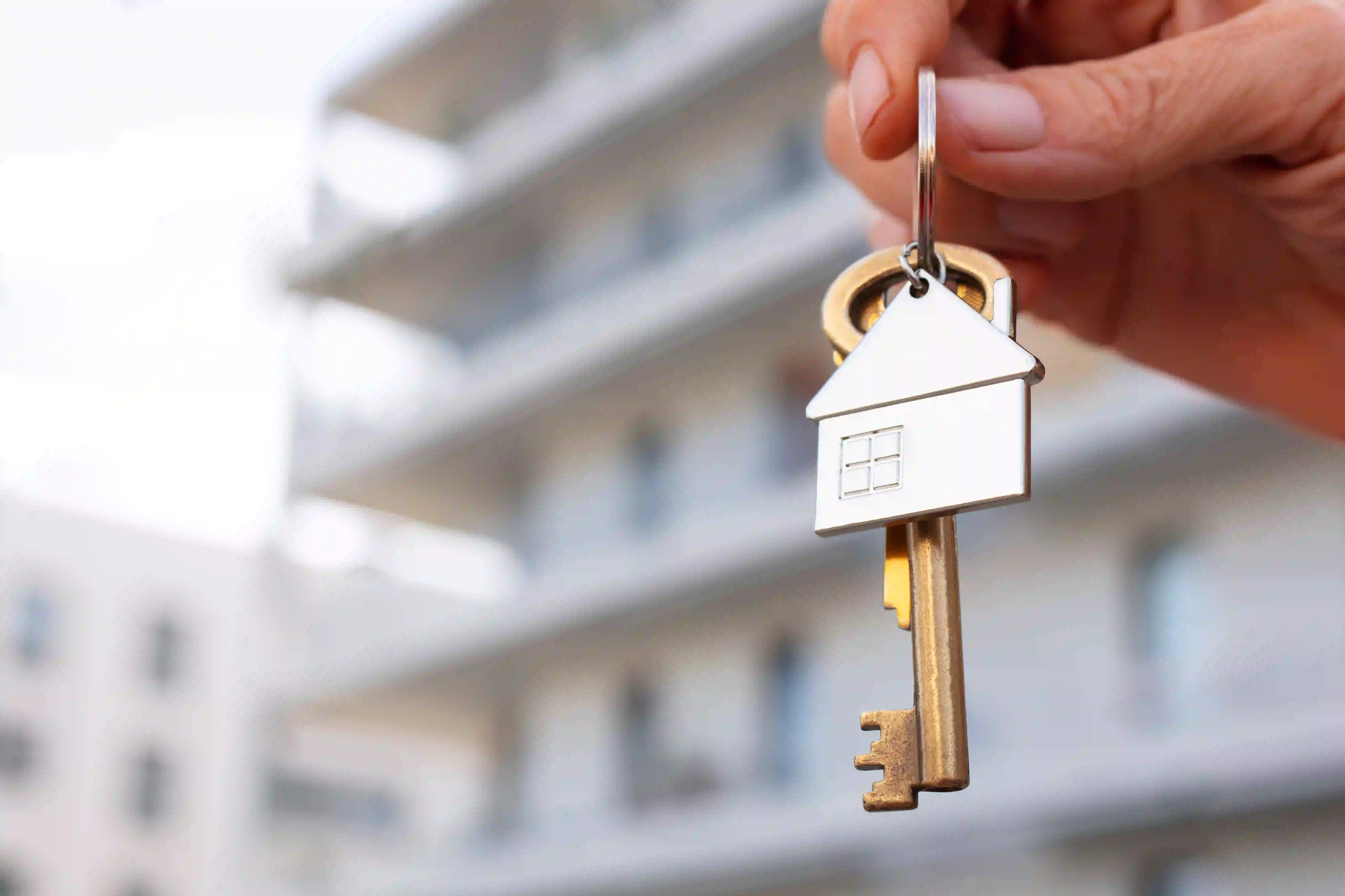 Hand holding house keys representing done for you social media posts for real estate agents.
