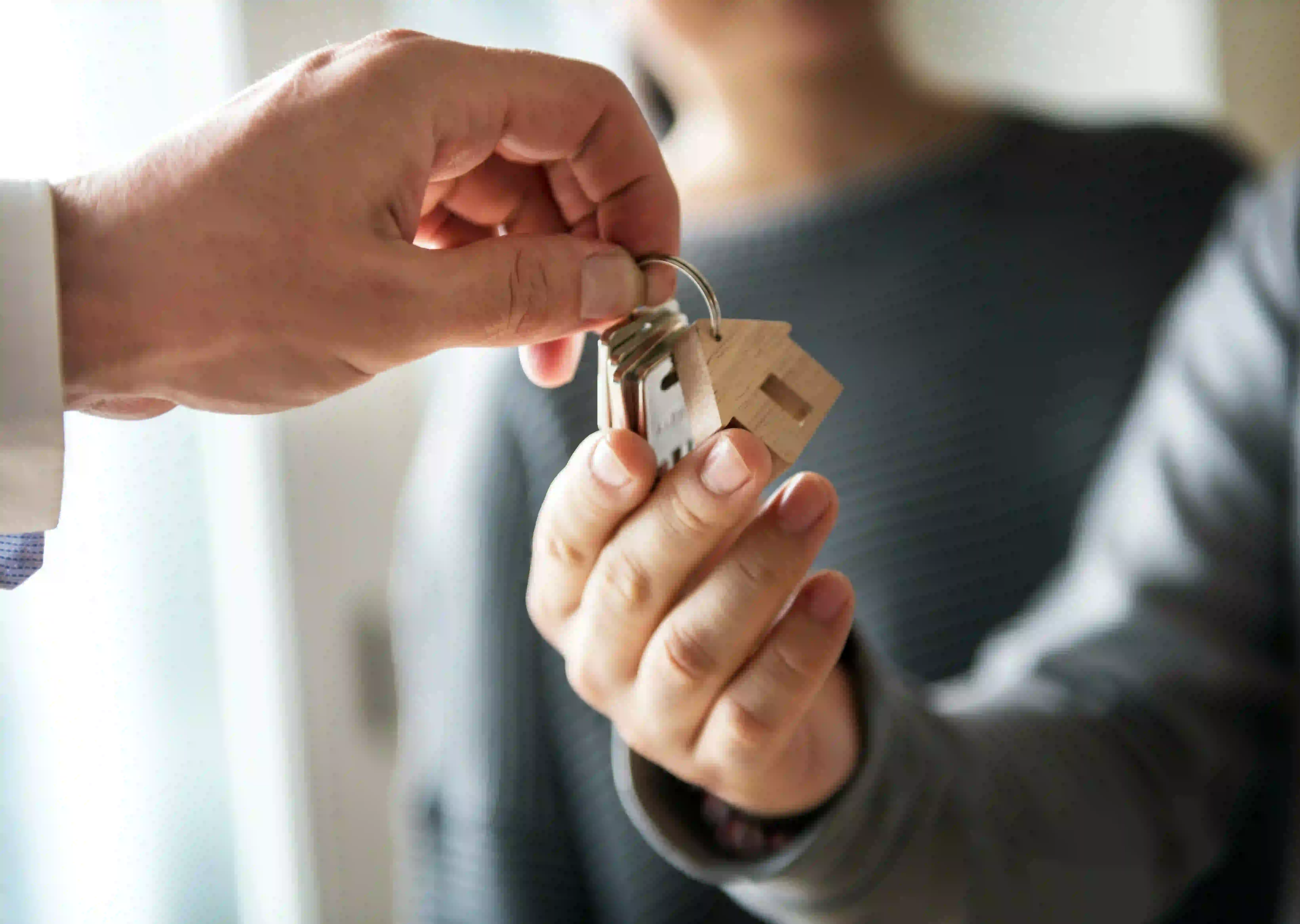 Agent handing over house keys showcasing real estate agent unique selling proposition examples.