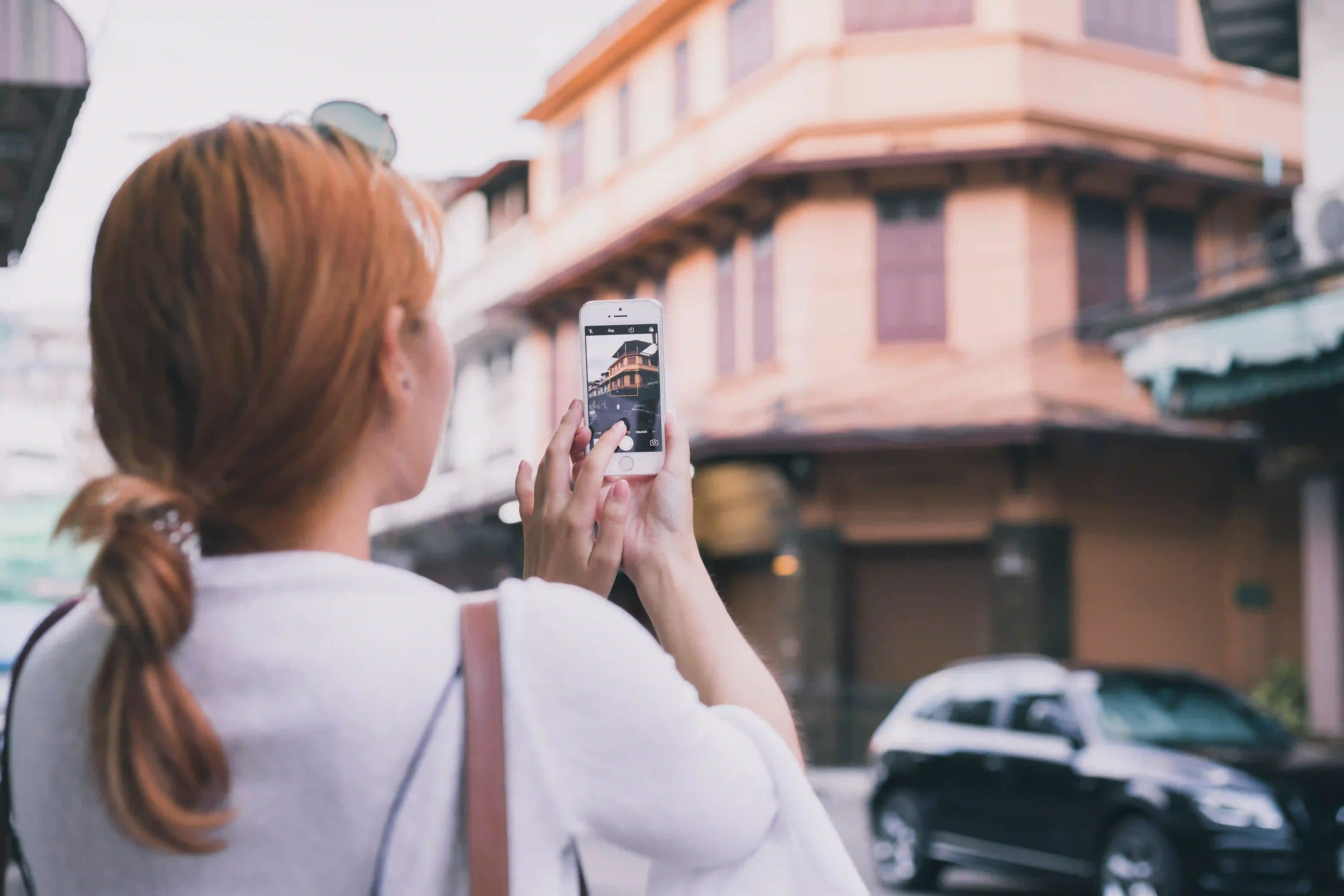 Woman photographing a property how to use Instagram Stories to generate real estate leads