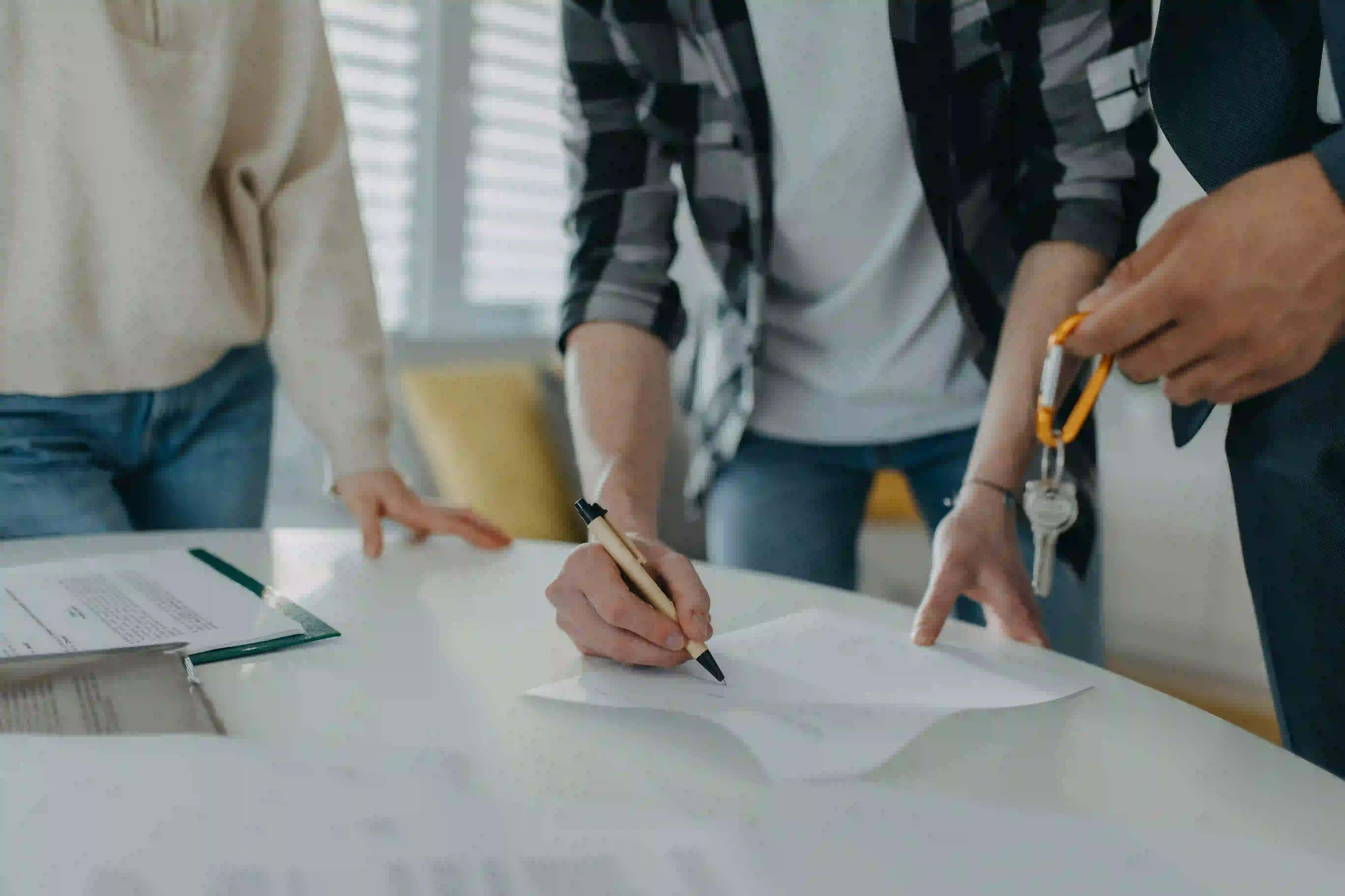 Clients signing property documents, illustrating real estate agent content ideas for Google Business Profile.